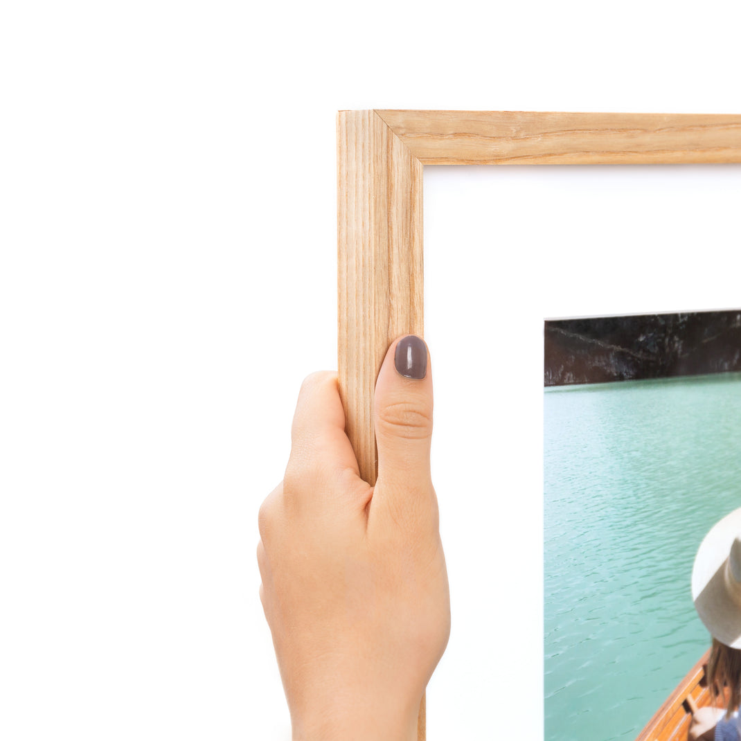 Top corner photo of Photo of a woman wearing a hat in a boat on a lake framed in Ash Gallery with a white mat