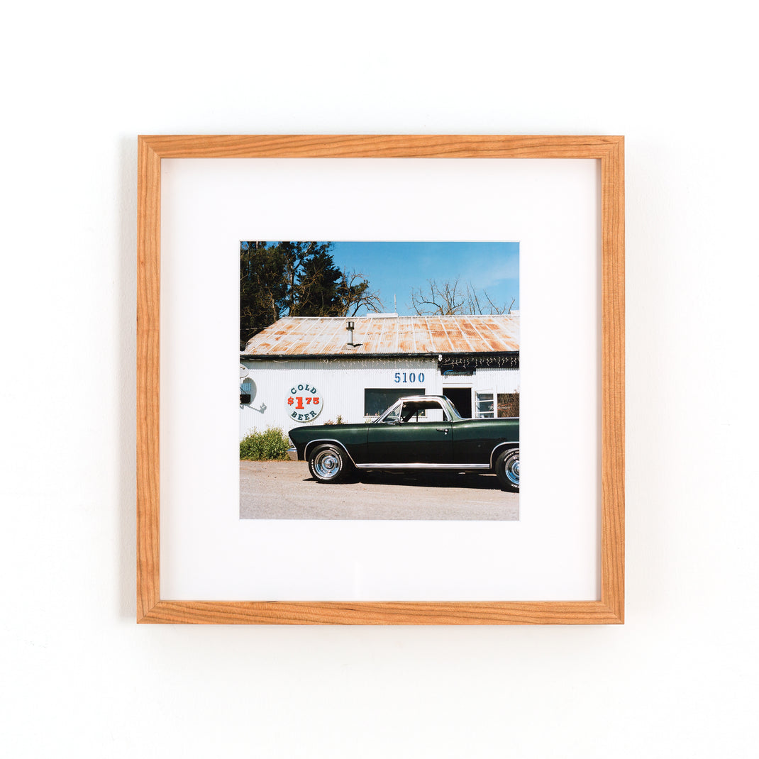 photograph of a vintage green car framed in cherry gallery frame with a white mat