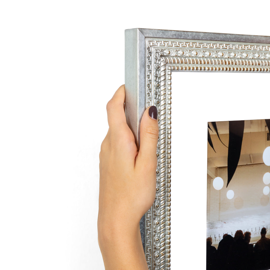 top left corner of a interior photo of a bar framed in ornate silver Brighton frame with a white mat