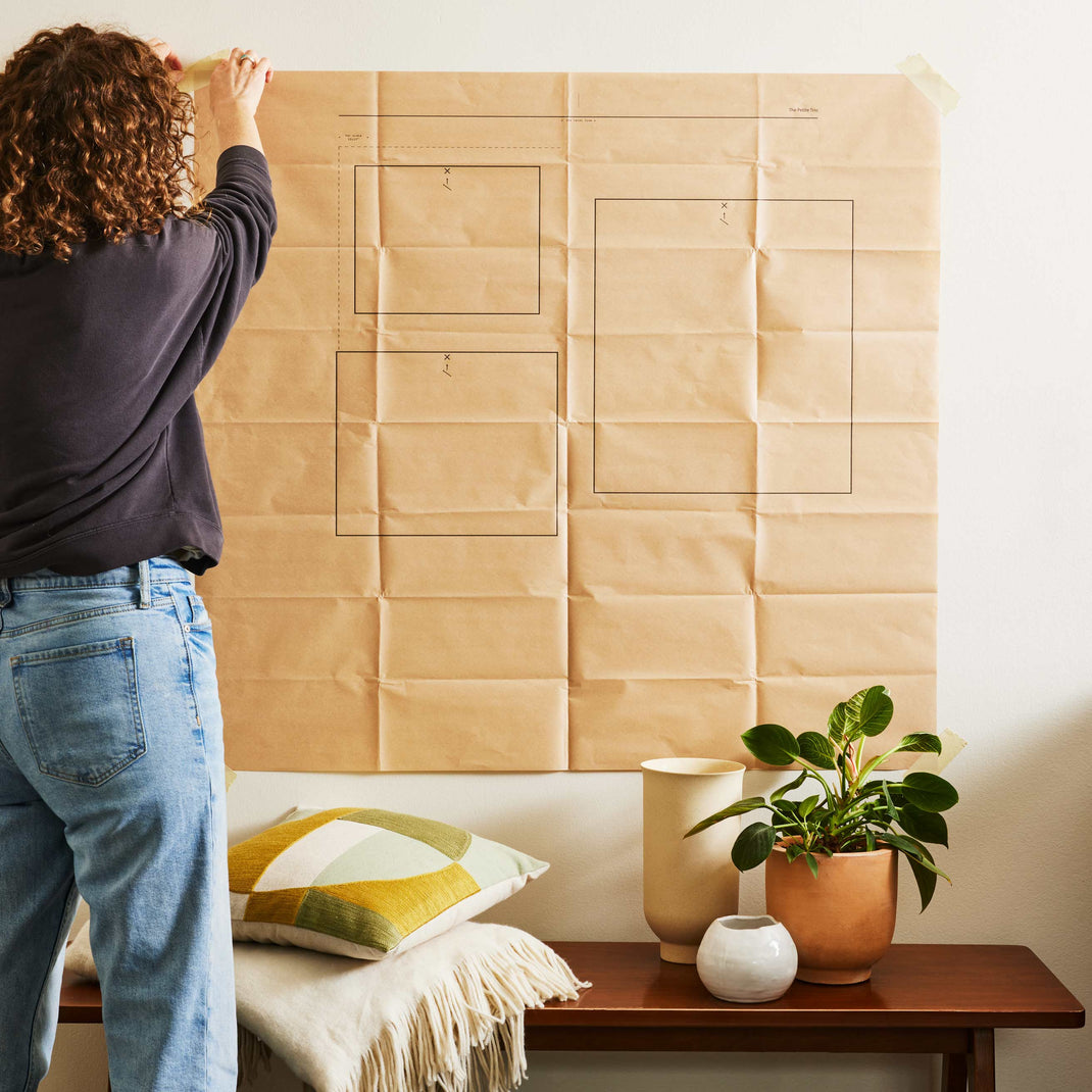 Woman utilizing the Timeless Trio Gallery Wall Hanging Guide