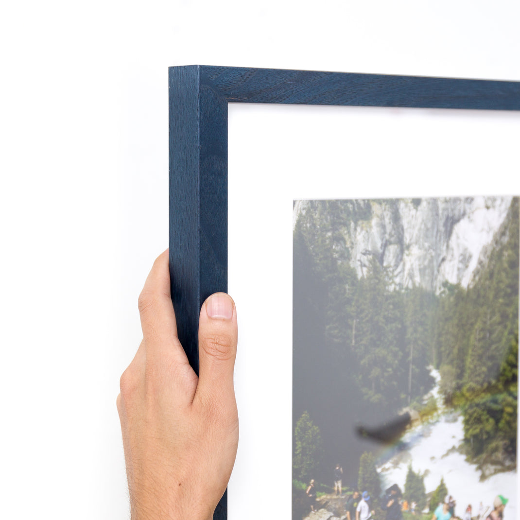 top left corner of photograph of hikers framed in Indigo Walnut frame with white mat