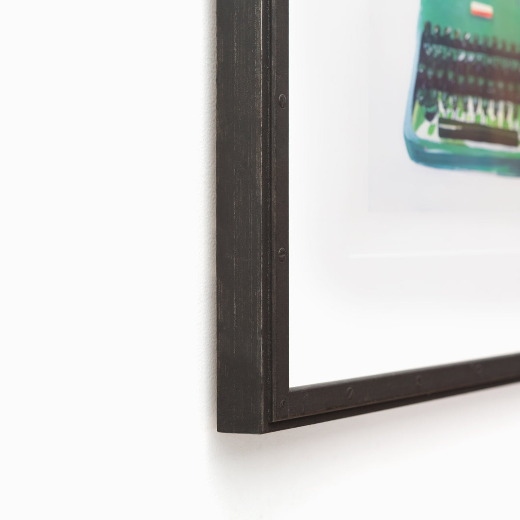 bottom left corner of art print of a typewriter framed in Bolton Riveted Wood Frame with a Black Steel Finish with white mat