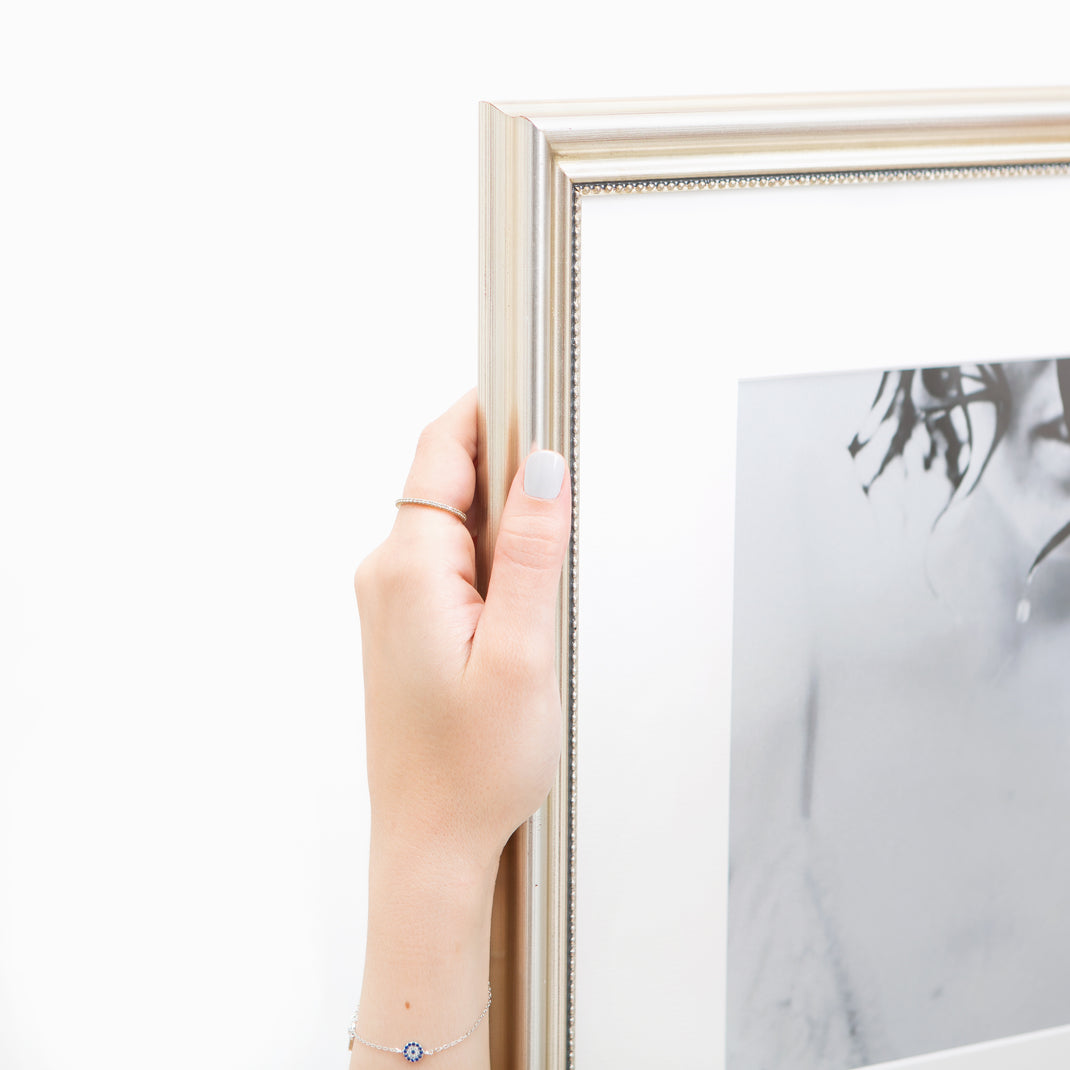 top left corner of black and white photo of a woman framed in Buckhead silver beaded frame with white mat
