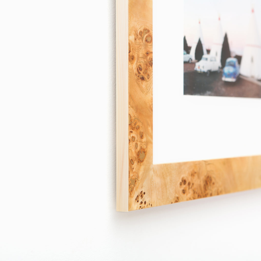 bottom left corner of photograph of tents at a campsite framed in Cairo burl wood frame with a white mat
