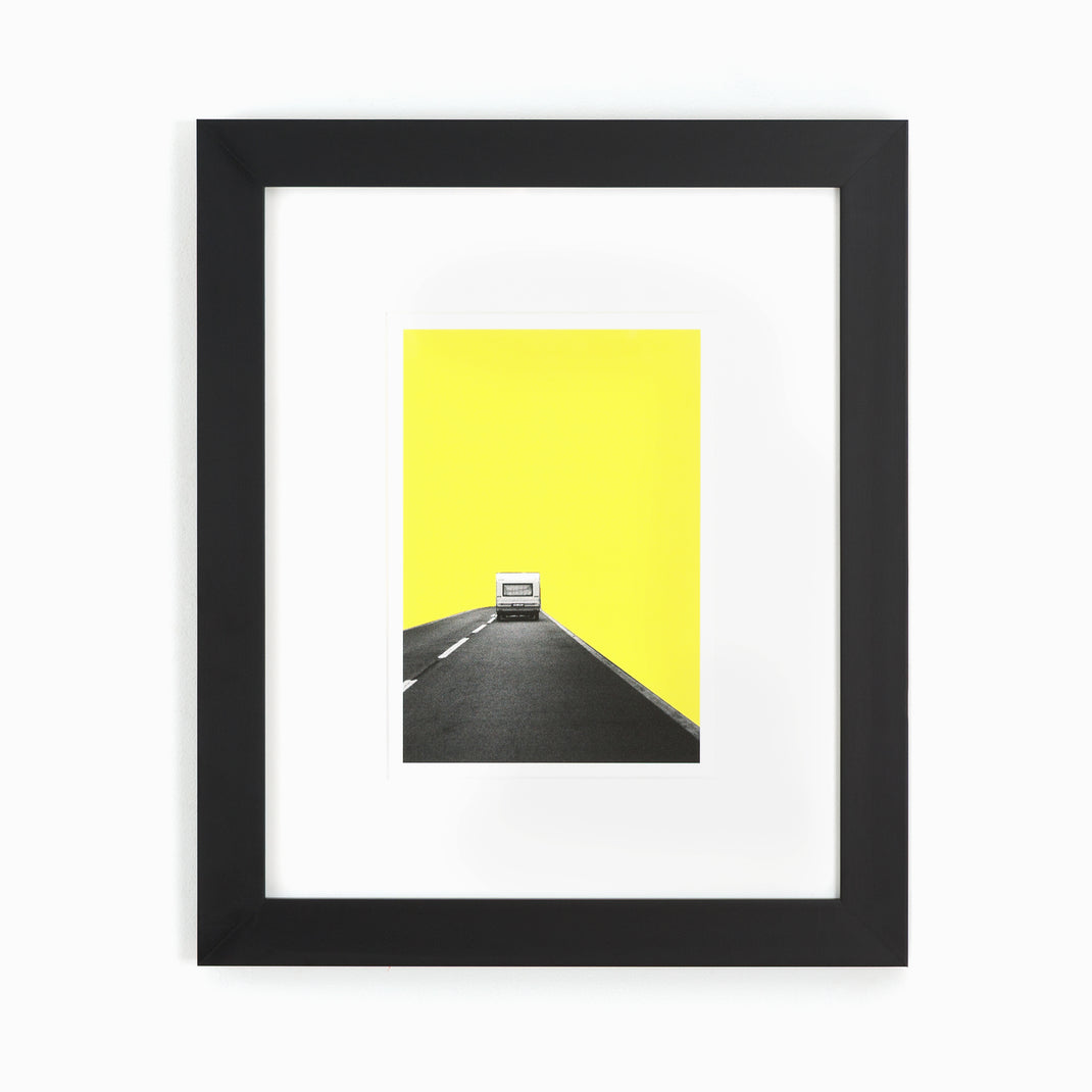 abstract print of a camper on a road with yellow sky framed in modern black Mercer frame with a white mat